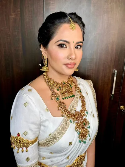 A close-up of the makeup and intricate gold jewelry, highlighting the timeless beauty of this look.