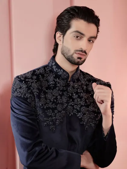 A confident portrait in our navy velvet embroidered jacket. It's a statement piece for the man who appreciates the finer things.