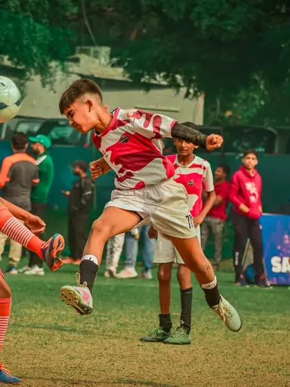 An aerial battle for a header, showcasing bravery and timing.