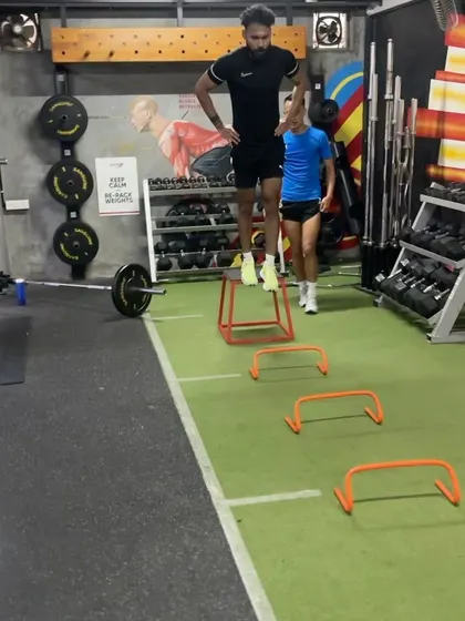 This image captures an athlete mid-air during a depth jump. This drill trains the body to absorb and redirect force quickly, which is crucial for explosive movements in any sport.