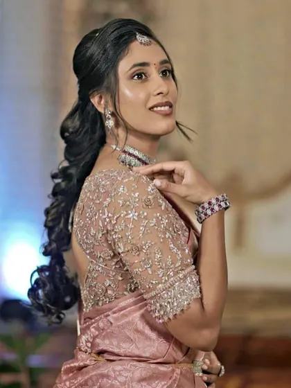 A beautiful side profile of the bride, showcasing the delicate embroidery on her blouse and her stunning jewelry.