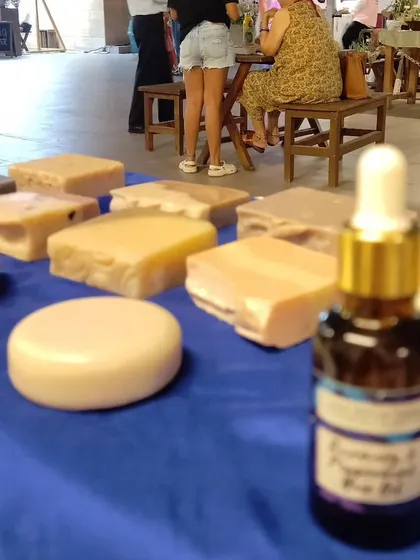 A close-up of my stall display, with the Rosemary & Peppermint Hair Oil bottle in focus and soap bars in the background.