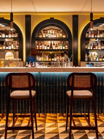 A slightly wider view of the bar at Vamos Experience, including the elegant fringed lamps. This shot provides more context, showing how the bar lighting and decor contribute to the venue's overall classic and sophisticated feel.