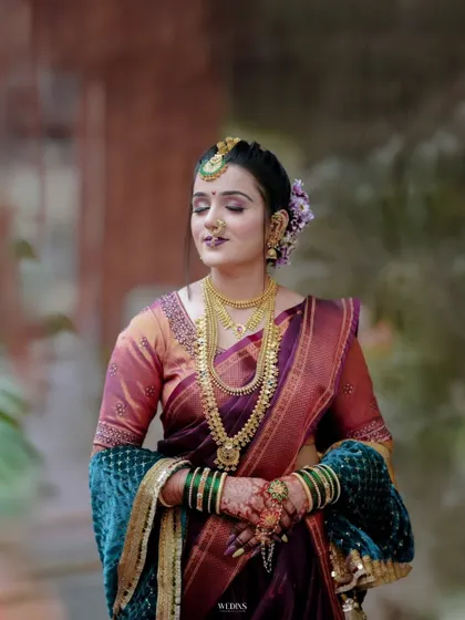 A classic bridal portrait showing the bride in her full splendor, with rich fabrics and heavy gold jewellery.