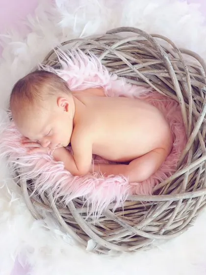 There is nothing more peaceful than a sleeping newborn. For this studio newborn session, I used a soft, nest-like prop to create a safe and cozy environment, allowing me to capture this baby's serene expression and delicate features.