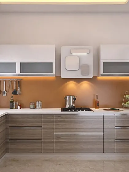 An L-shaped kitchen with a cheerful combination of wood-finish lower cabinets and white upper cabinets. The orange back-painted glass adds a vibrant splash of color.