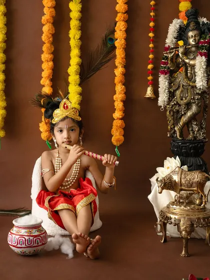 A classic pose of a young Krishna with his flute, set against a traditional backdrop.
