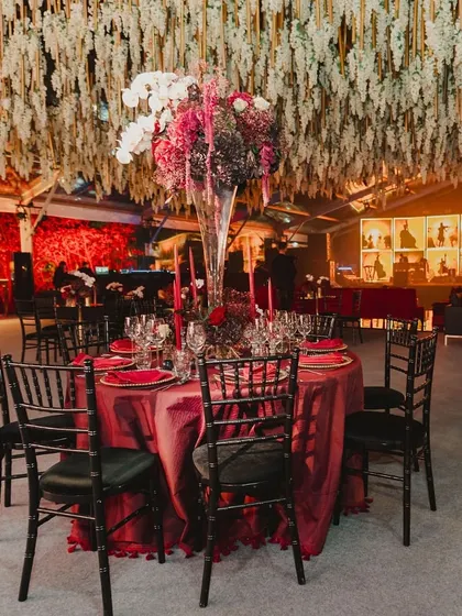 A look inside a glamorous red and maroon themed cocktail night, with velvet textures, a custom poker theme, and a stunning floral-decked bar.