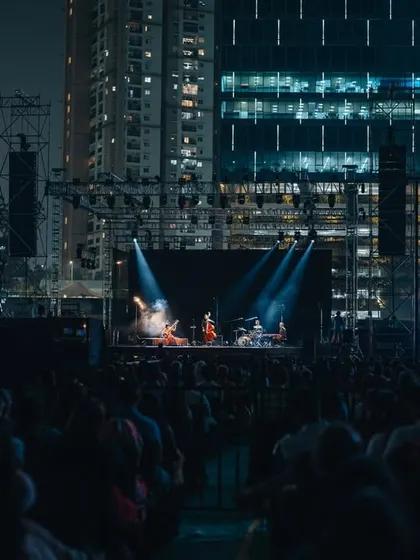 Anoushka Shankar's concert set against a stunning urban backdrop, with high-rise buildings lit up behind the stage.