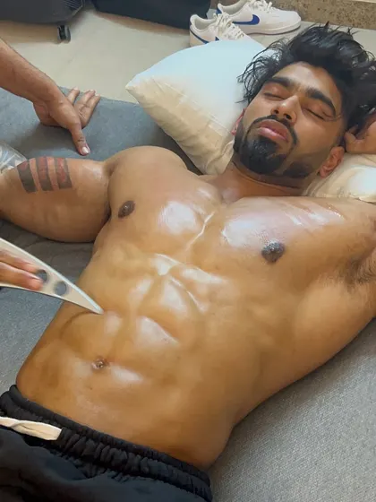 Using a specialized IASTM tool on the chiseled abs of a professional athlete. This technique enhances muscle separation and definition.