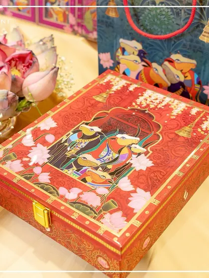 This ornate red gift box from the Pichwai collection is a statement piece in itself. The intricate artwork and bold color make it a perfect choice for a wedding celebration steeped in traditional hues.