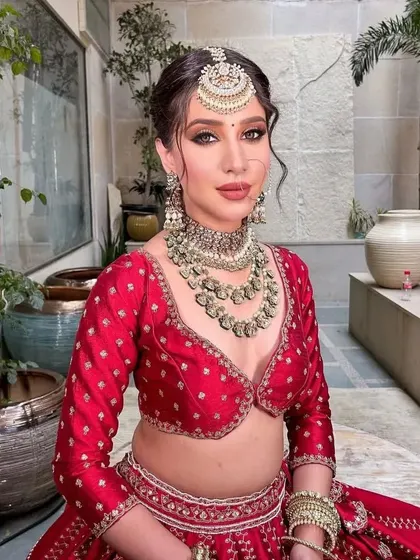 Presenting the Aafreen bride. A close-up on the stunning layered kundan jewelry and the deep V-neck blouse of this traditional red lehenga.