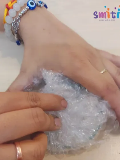 A teacher demonstrates how to prepare the bubble wrap for printing. Our educators guide children through each step of the creative process.