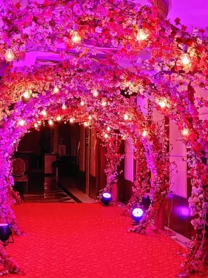 Another view of the stunning floral entrance tunnel, this time illuminated with vibrant pink lighting. The effect is glamorous and sets an exciting tone for a night of music and dance.