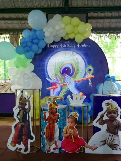 A unique and beautiful Krishna theme for a birthday celebration. The decor features a stunning backdrop of Lord Krishna, with cutouts of the birthday girl dressed in character.