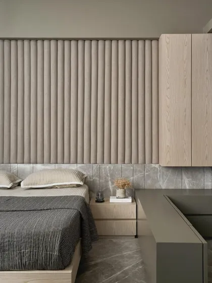 This versatile room serves as both a guest room and a family room. We used a monochromatic palette and integrated furniture to fit a queen bed, a large sofa, a wardrobe, and a TV into a compact space.