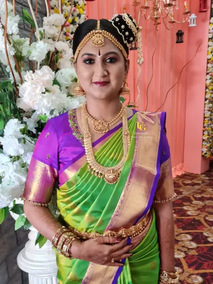 A full-length view of Aishwarya in her stunning green and purple silk saree, complete with traditional hair and jewellery.