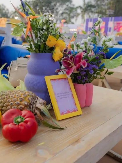 The decor was designed to be touched and experienced. Here, fresh pineapples and bell peppers sit alongside floral arrangements, creating a multi-sensory tablescape that is both beautiful and unconventional.