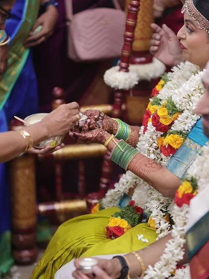 A candid moment from a wedding ritual, showing the bride's beautifully stained hands.