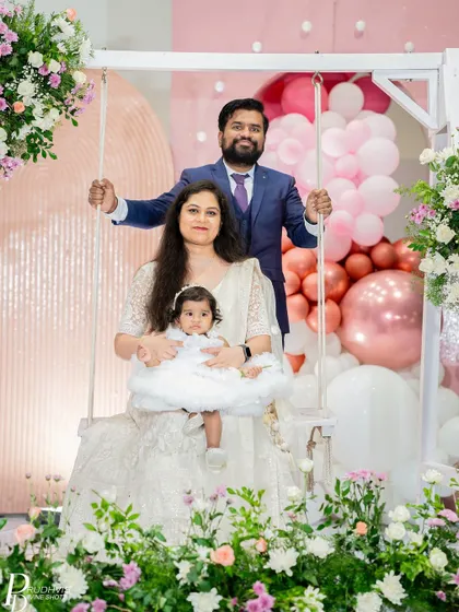 A happy family portrait on the floral swing, a centerpiece we designed for this enchanting fairy-themed celebration.
