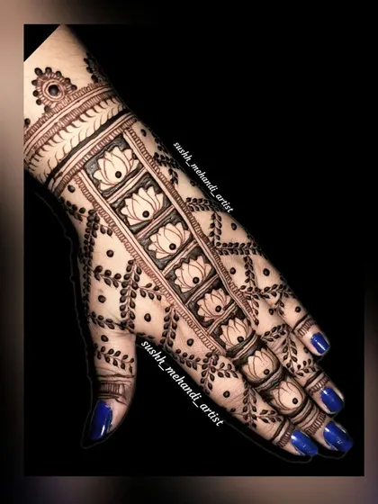 A close-up of the lotus panel design on the back of the hand. The dark blue nails provide a beautiful contrast.