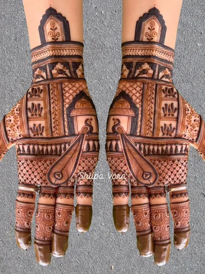 A symmetrical design featuring peacocks inside jharokhas, with intricate patterns filling the rest of the hand.