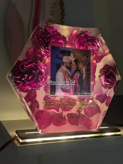This hexagonal piece is actually a night lamp. It preserves beautiful pink roses and a photo, and the wooden base lights up to create a warm glow.
