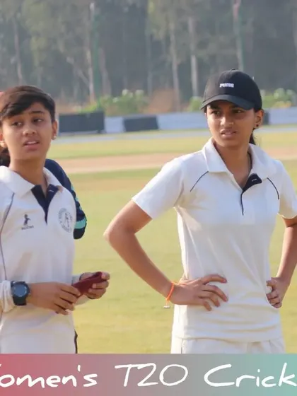 Players watching the game intently from the boundary line.