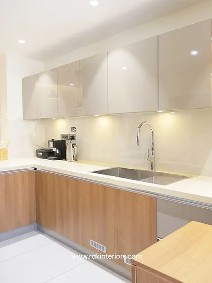 A modern kitchen design that combines glossy white upper cabinets with warm wood lower cabinets. The open shelving with backlighting is perfect for displaying decor items.