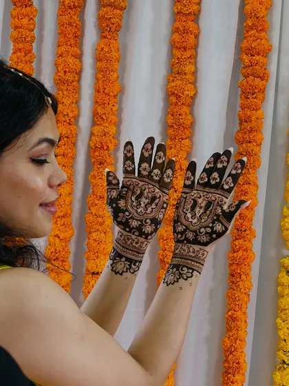 The bride posing with her wedding mehendi, her smile as bright as the henna.