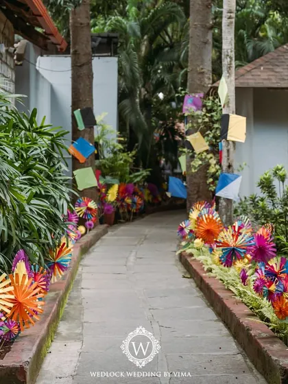 A pathway lined with colorful, handcrafted pinwheels and kites for a carnival-themed Mehendi. These playful details created a whimsical entrance for guests.