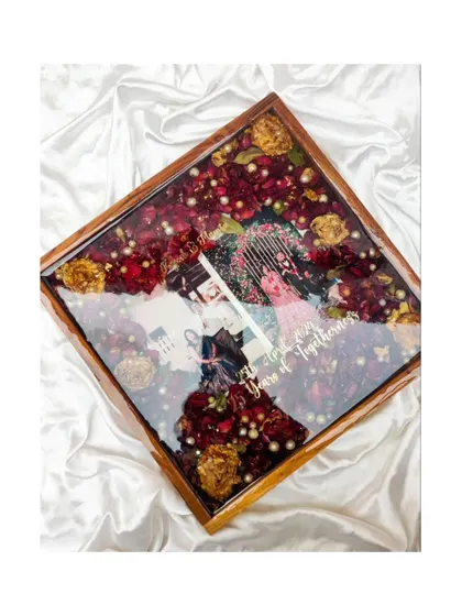 Cherishing 25 years of love in resin. This square teakwood frame, filled with deep red roses, is a luxurious and heartfelt gift for a silver wedding anniversary.