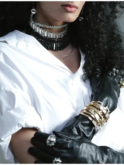 A detailed shot focusing on layered necklaces and bracelets from a FAD International collaboration. This image emphasizes accessory styling, showing how jewelry can be the centerpiece of a look.