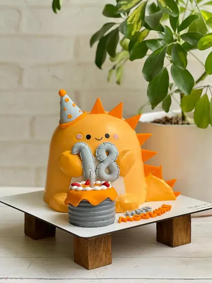 A cute and friendly dinosaur cake for an 18th birthday. This sculpted cake shows that themed cakes aren't just for kids.