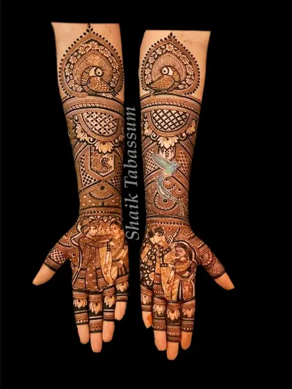 Peacock motifs gracefully frame the top of this design, which flows down into detailed patterns and a lovely family portrait on the palms.