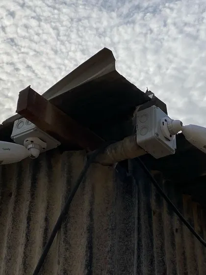 Two cameras installed on a rustic corrugated metal structure. I can mount cameras securely on any type of surface.