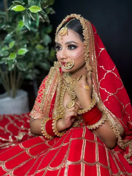 A seated portrait of the bride, surrounded by her beautiful red lehenga. The makeup is kept classic and elegant to match the traditional vibe.