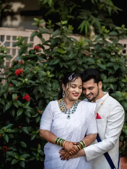 A serene couple portrait in their white wedding attire, often worn for Buddhist Marathi ceremonies. The focus is on their quiet connection and the elegant simplicity of their look.