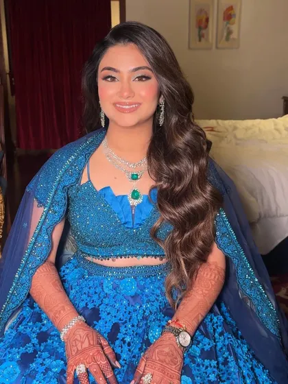 A real-life princess in blue. This full-shot photo shows how the complete look comes together, with the makeup and hair balancing the vibrant, detailed lehenga.