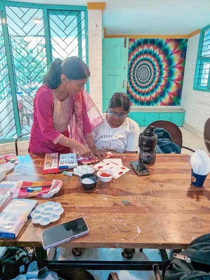 A one on one moment of guidance during our watercolour workshop, ensuring every participant feels supported.
