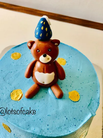 A detailed look at the handmade fondant teddy bear topper, complete with a little party hat. It's these small, personalized details that make a custom birthday cake extra special.