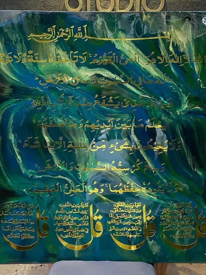 This piece features Ayat al-Kursi and the Four Quls against a dynamic background of swirling emerald, sapphire, and gold resin. The sides are heavily textured with crushed glass and crystals, adding a raw, glittering contrast to the smooth center.