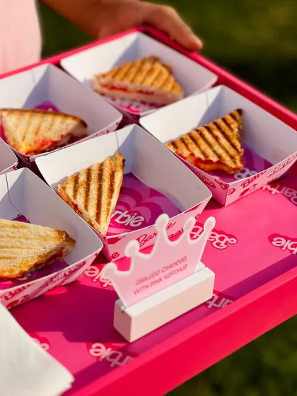 Grilled cheese sandwiches, a classic comfort food, cut into triangles and served with pink ketchup to match the Barbie theme.