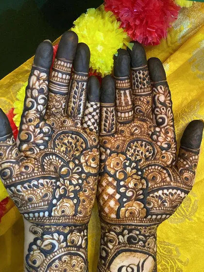 A close-up of the palms, showing the detailed finger work and the personalized initials.