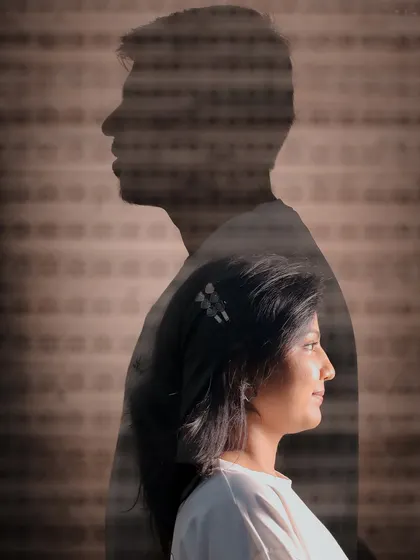 An artistic double exposure portrait, overlaying the couple's profiles to symbolize their union. The subtle texture adds depth and a cinematic quality to the image.