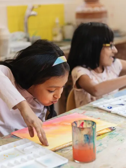 A young artist learns the art of patience while waiting for her watercolor painting to dry. We teach that getting a bit messy is all part of the creative process.