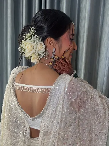 Another angle of the beautiful hairstyle, showing the intricate details of the bun and floral placement.