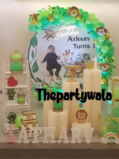 A personalized jungle theme with a photo of the birthday boy on the backdrop.