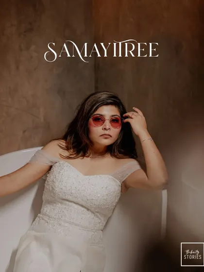 A stylish portrait of the bride in a white gown and cool sunglasses, relaxing in a bathtub for a modern and chic pre-wedding shot.