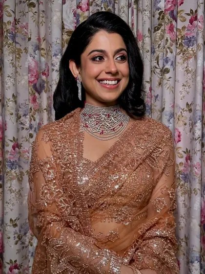 Her smile lights up the room. The flicked eyeliner and flushed cheeks give her a fresh, youthful, and glamorous appearance.